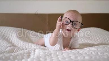 婴<strong>儿时</strong>代，戴着眼镜的蓝色大眼睛的可爱小男孩的画像躺在床上，紧紧地
